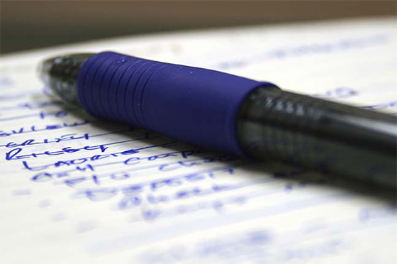 Blue pen and pad with written list