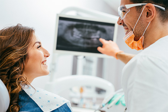 Dentist explaining dental x-rays on iPad to female patient