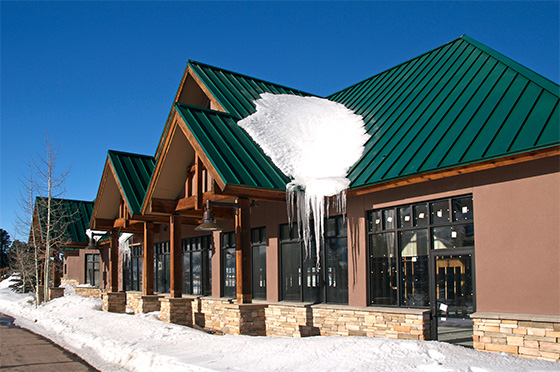 Snow covered business building near mountains in the background