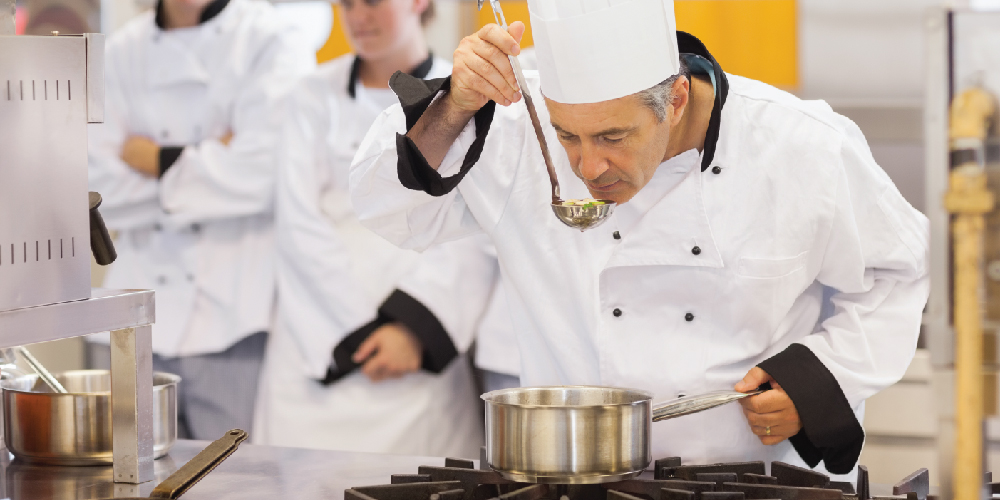 Professional chef tasting soup from a ladle