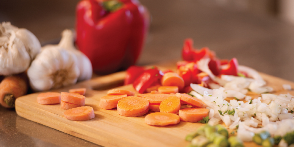 Sliced ingredients for soup sitting on cutting board