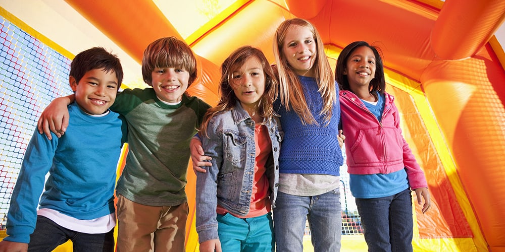 Diverse group of children playing in a bouncy house