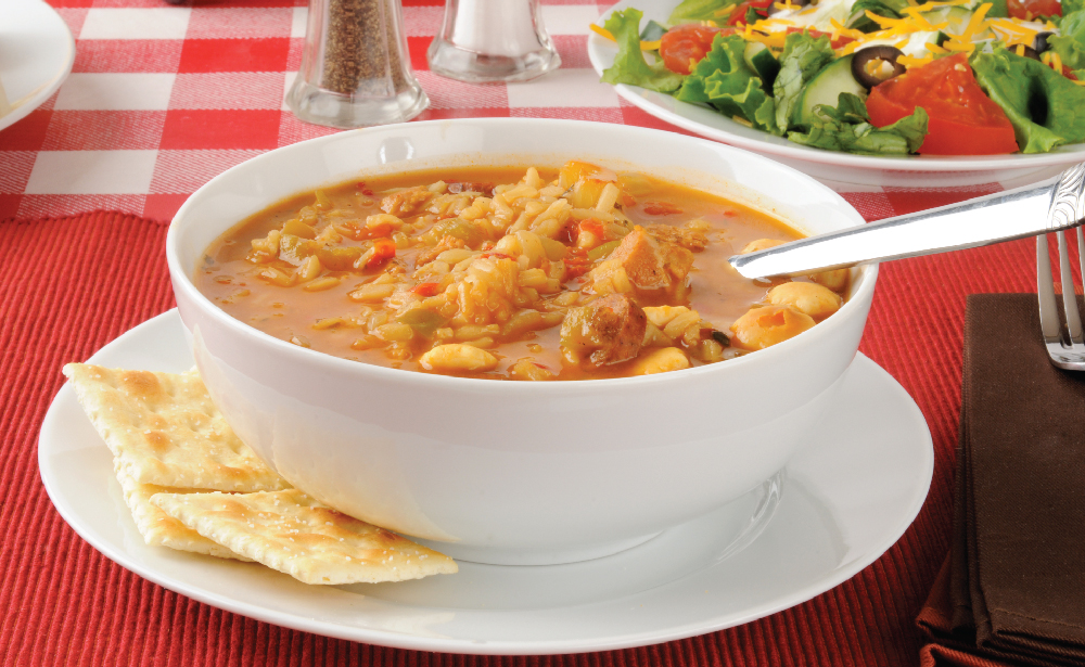 Bowl of soup with crackers and a side salad