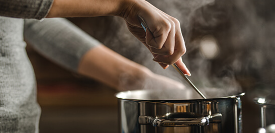 person stirring soups