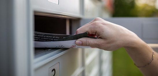 Hand pulling out mail from mail box